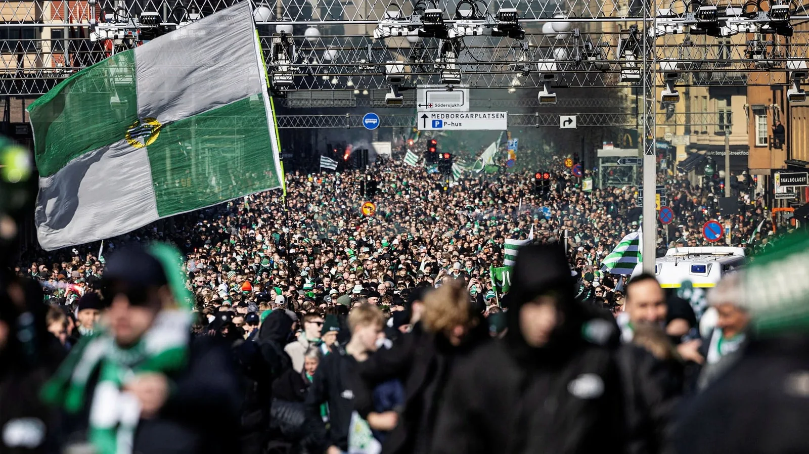 Supportrar med flaggor och rök på läktaren under en match i Allsvenskan 2025